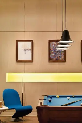 a room with a pool table and a blue chair at Aloft Harlem in New York