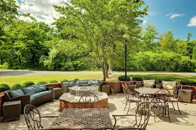 a patio with tables and chairs in a park at Hilton Garden Inn Albany Airport in Albany
