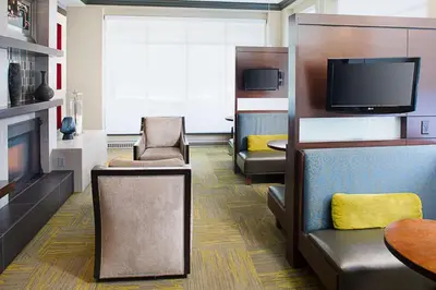 a living room with a couch and a tv at Hilton Garden Inn Albany Airport in Albany