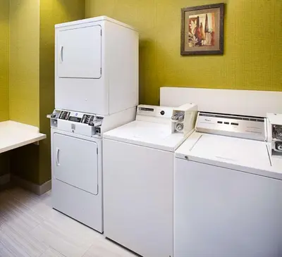 two washer and dryers sitting in a room at Hilton Garden Inn Albany Airport in Albany