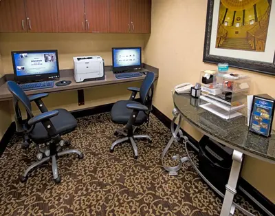 a room with a desk with two computers and chairs at Hampton Inn Schenectady Downtown in Schenectady