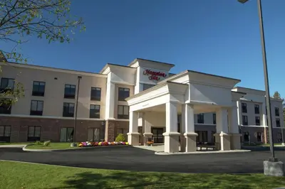 a hotel with a white building with a parking lot at Hampton Inn Bennington in Bennington