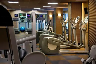 a gym with treadmills and elliptical machines at Stamford Marriott Hotel & Spa in Stamford