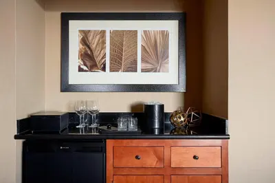 a picture hanging on a wall above a counter with wine glasses at Stamford Marriott Hotel & Spa in Stamford