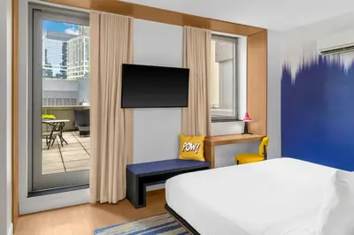 a bedroom with a bed and a view of a balcony at Aloft New York Brooklyn in Brooklyn
