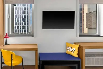 a room with a desk and a tv and a yellow chair at Aloft New York Brooklyn in Brooklyn