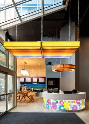 a lobby with a yellow chandelier in a building at Aloft New York Brooklyn in Brooklyn
