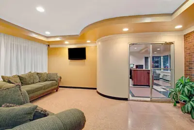 a living room with a couch and a tv at Super 8 by Wyndham Milford/New Haven in Milford