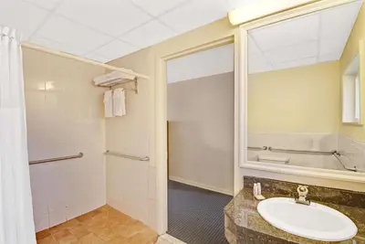 a bathroom with a sink and a mirror at Super 8 by Wyndham Milford/New Haven in Milford