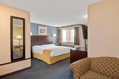 a hotel room with a bed and a mirror at Super 8 by Wyndham Milford/New Haven in Milford