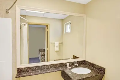 a bathroom with a sink and a mirror at Super 8 by Wyndham Milford/New Haven in Milford