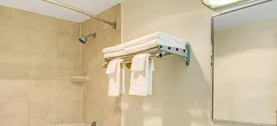 a bathroom with a shower with towels on a wall at Super 8 by Wyndham Stamford/New York City Area in Stamford