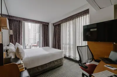 a hotel room with a bed and a large window at The Jewel Hotel, New York in New York