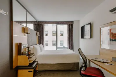 a hotel room with a bed and a desk at The Jewel Hotel, New York in New York