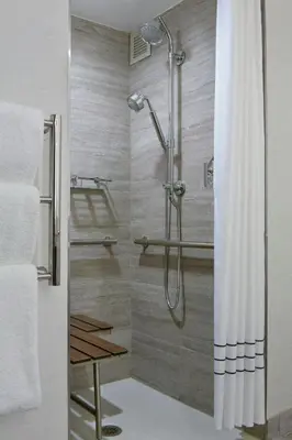 a shower with a glass door in a bathroom at New York LaGuardia Airport Marriott in Queens