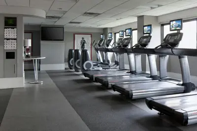 a gym with a row of treadmills and machines at New York LaGuardia Airport Marriott in Queens