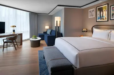 a hotel room with a large bed and a couch at The Opus Westchester, Autograph Collection in White Plains
