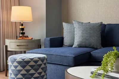 a living room with a blue couch and a table at The Opus Westchester, Autograph Collection in White Plains