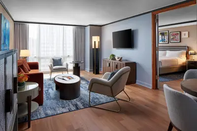 a hotel room with a king bed and a living room at The Opus Westchester, Autograph Collection in White Plains
