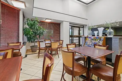 a dining room with tables and chairs in a restaurant at Days Inn by Wyndham Utica in Utica