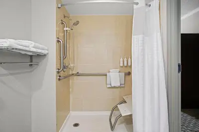 a bathroom with a shower with a shower curtain at Days Inn by Wyndham Utica in Utica
