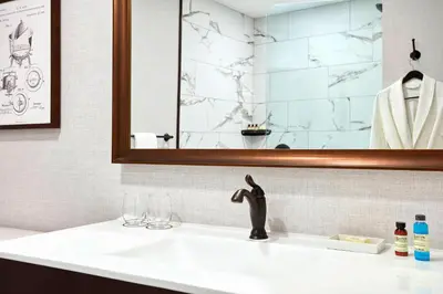 a bathroom with a sink and a mirror at The Wick, Hudson, a Tribute Portfolio Hotel in Hudson