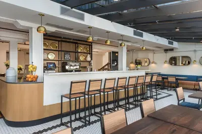 a dining room with chairs and a bar at The Wick, Hudson, a Tribute Portfolio Hotel in Hudson