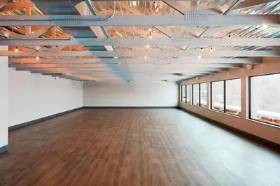 an empty room with wood floors and windows at The Wick, Hudson, a Tribute Portfolio Hotel in Hudson