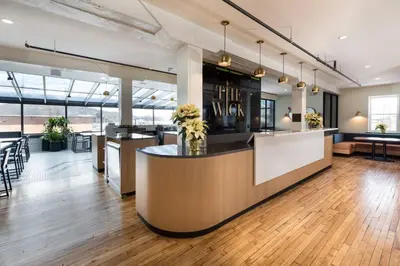 a lobby with a counter and a bar in a building at The Wick, Hudson, a Tribute Portfolio Hotel in Hudson