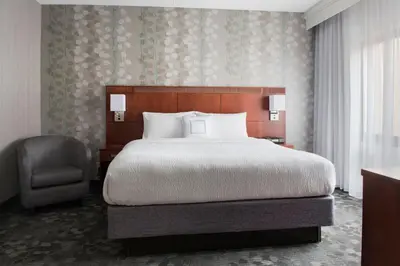 a hotel room with a bed and a chair at Courtyard by Marriott Mahwah in Mahwah