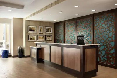 a hotel lobby with a reception counter with blue and green wallpaper at Homewood Suites By Hilton Hartford Manchester in Manchester