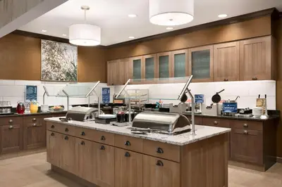 a kitchen with wooden cabinets and a counter top at Homewood Suites By Hilton Hartford Manchester in Manchester