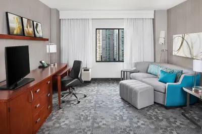 a hotel room with a couch and a desk and a living room at Courtyard By Marriott Jersey City Newport in Jersey City