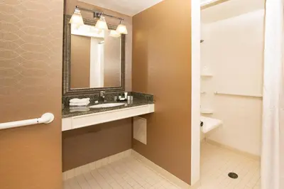 a bathroom with a sink and a mirror and a toilet at Sheraton Hartford South in Rocky Hill