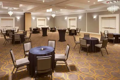 a banquet hall with tables and chairs and chandeliers at Sheraton Hartford South in Rocky Hill