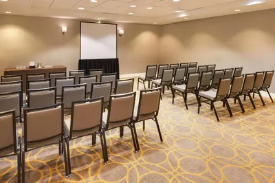 a conference room with a row of chairs and a whiteboard at Sheraton Hartford South in Rocky Hill
