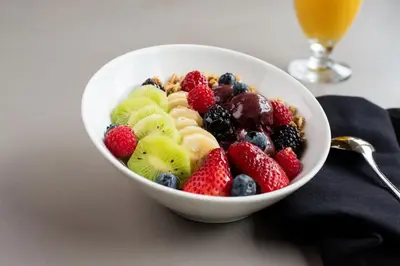 a bowl of fruit on a table with a drink at Sheraton Hartford South in Rocky Hill