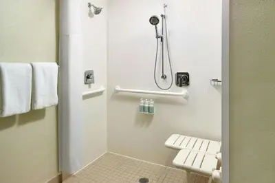 a small bathroom with a shower and a toilet at Courtyard By Marriott Hartford Windsor Airport in Windsor