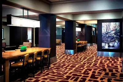 a dining room with tables and chairs and a large window at Trumbull Marriott Shelton in Trumbull