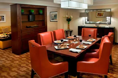 a dining room with a table and orange chairs at Trumbull Marriott Shelton in Trumbull