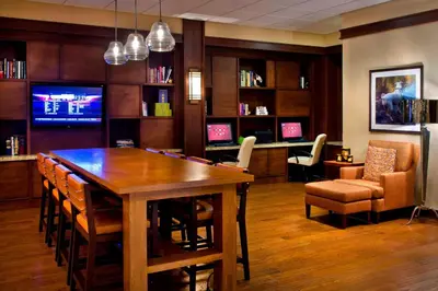 a dining room with a large wooden table and chairs at Trumbull Marriott Shelton in Trumbull