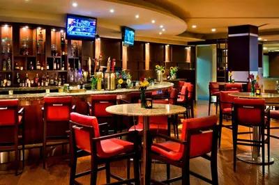 a bar with red chairs and tables in a restaurant at Trumbull Marriott Shelton in Trumbull