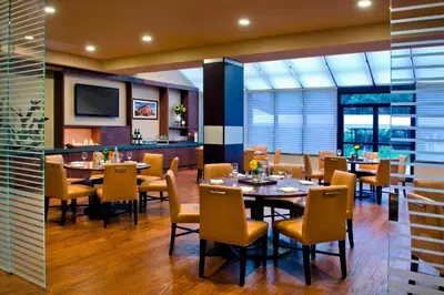 a restaurant with tables and chairs and a television at Trumbull Marriott Shelton in Trumbull