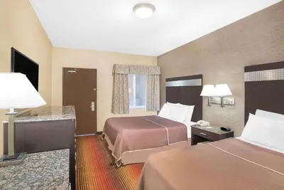 a hotel room with two beds and two lamps at Howard Johnson by Wyndham North Bergen in North Bergen