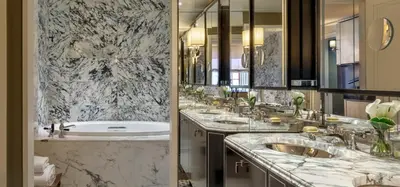 a bathroom with three sinks and a bath tub at The Carlyle, A Rosewood Hotel in New York