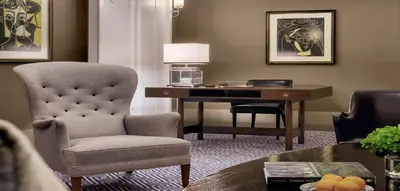 a living room with a desk and a chair and a chair at The Carlyle, A Rosewood Hotel in New York