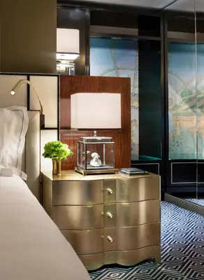 a hotel room with a bed and a dresser at The Carlyle, A Rosewood Hotel in New York