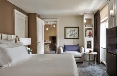 a bedroom with a bed and a living room at The Carlyle, A Rosewood Hotel in New York