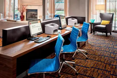 a conference room with a desk with computers and blue chairs at Courtyard Parsippany in Parsippany
