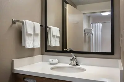 a bathroom with a white sink and a mirror at SpringHill Suites Danbury in Danbury